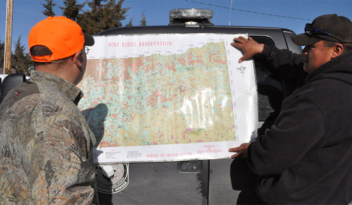 hunter and guide scan a map of the Pine Ridge Indian Reservation