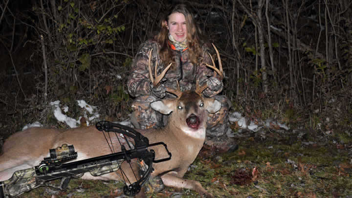 female hunter with whitetail buck