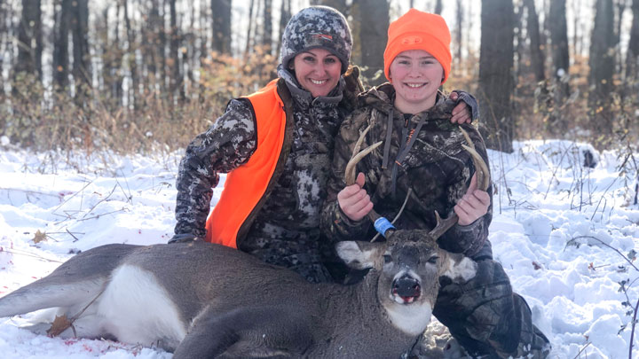 mother and son pose with a whitetail buck