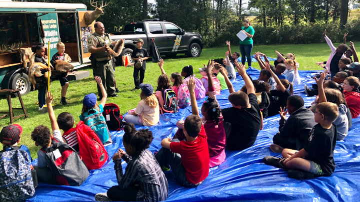 Children listen to Illinois Conservation Police Officer Steve Beltran discuss wildlife at a show-and-tell event.