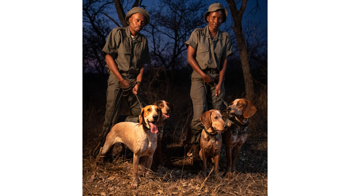 dog handlers pose with their scent hounds