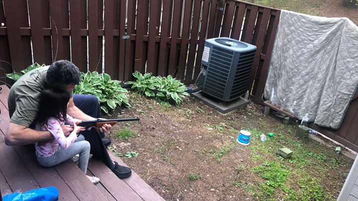 father teaches daughter how to shoot a bb gun