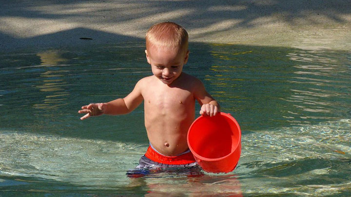 little boy plays in a pool