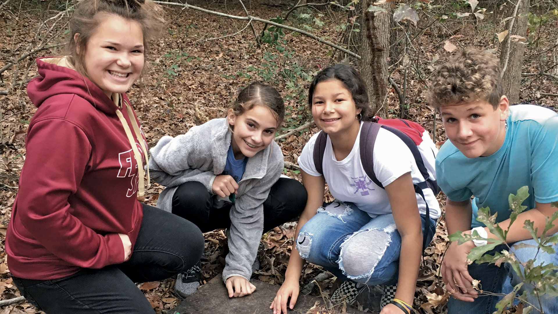 school-age children gather to learn about the outdoors in an outdoor classroom