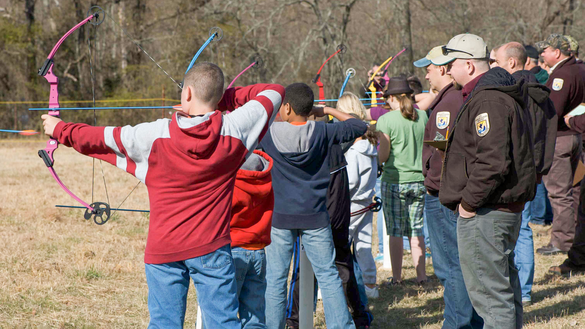 group of teens practices archery target shooting