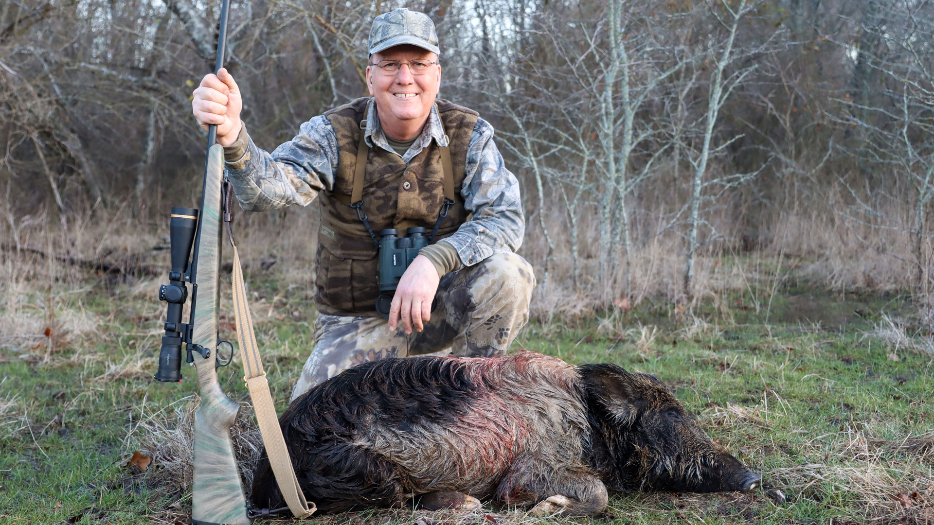 the author poses with a hog and his mg arms rifle